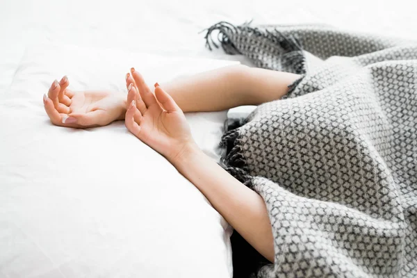 Covered woman with protruding hands out of blanket