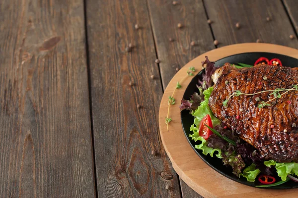 Roasted duck thigh on wooden table, free space