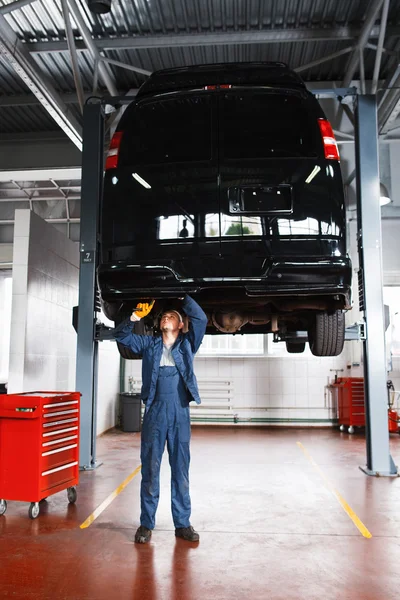 Mechanic working with car suspension system