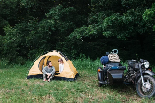 Family camping, dad with daughter in forest