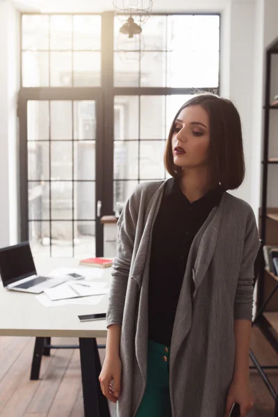 Surprised business woman, standing in office.