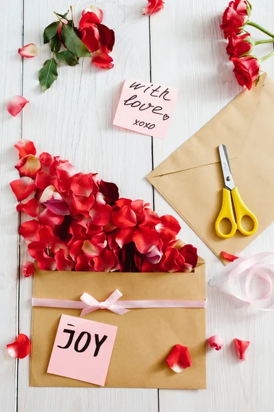 Making love message with envelope and rose petals