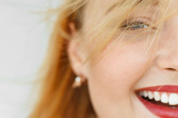 Half face of laughing red-haired woman