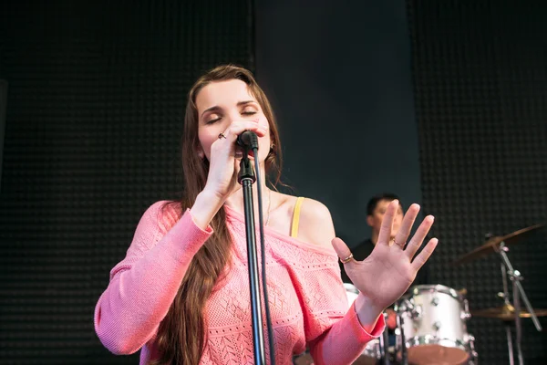 Emotionally singing into microphone woman