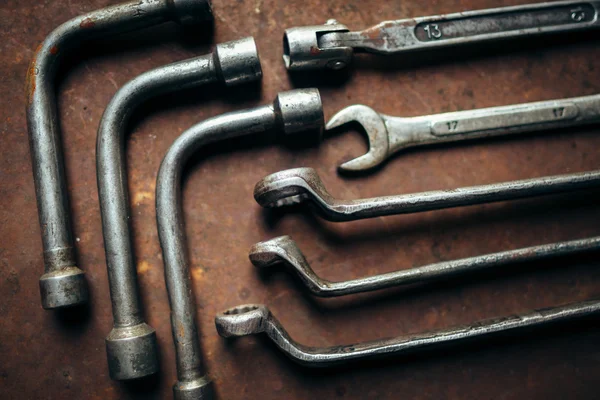 Set of wrenches on a rusty dark metal background