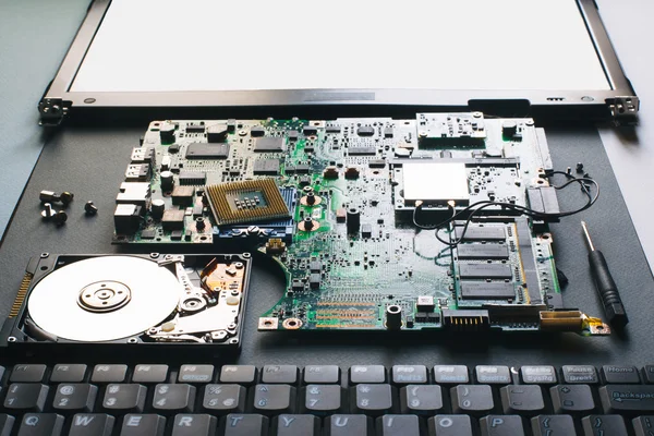 Disassembled computer (laptop) parts: matherboard, hdd, monitor