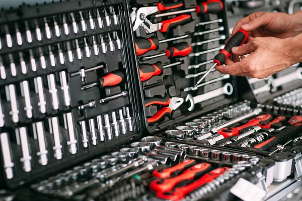 Chooses wrench tools (screwdriver) in store (shop)