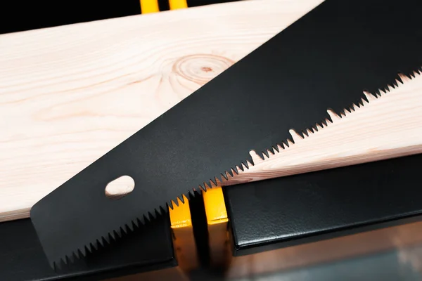Hand saw on the wooden workshop background