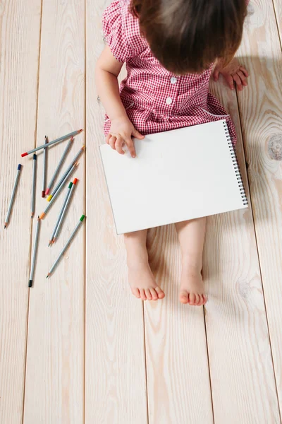 Little girl drawing pencils