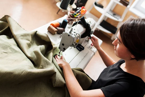 Seamstress sews clothes. Workplace of tailor