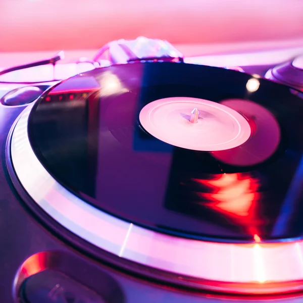 Turntable playing vinyl with club lighting