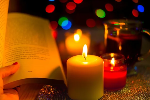 Reading book in light of candles