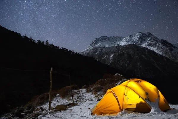 Tent in mountains under starry sky