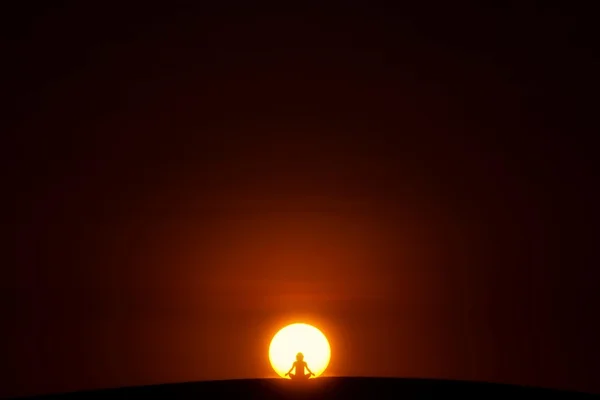 Person in Lotus pose in center of sun