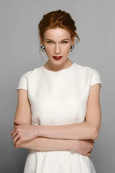 Stylish fashion model with red mat lips and gemstone earrings