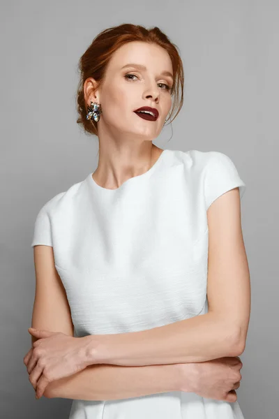 Stylish fashion model with red mat lips and gemstone earrings