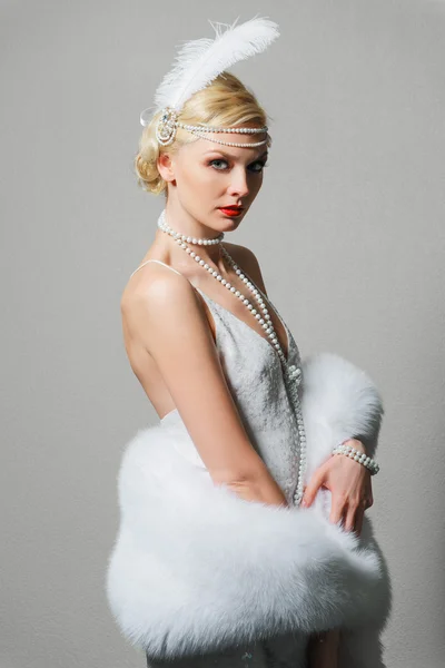 Woman in white dress with shoulder straps and long fur boa