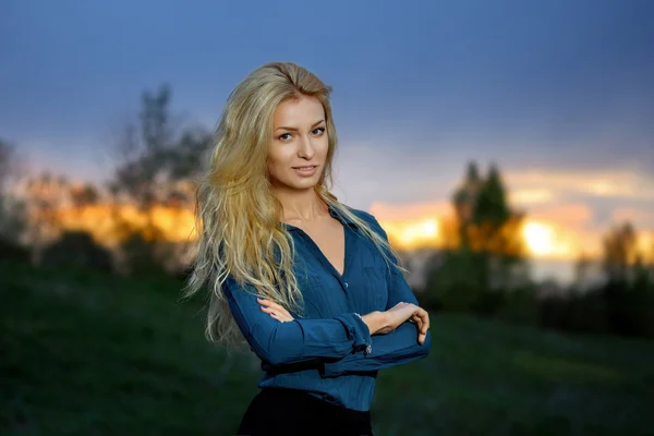 Outdoor portrait of pretty blonde woman in sunset time