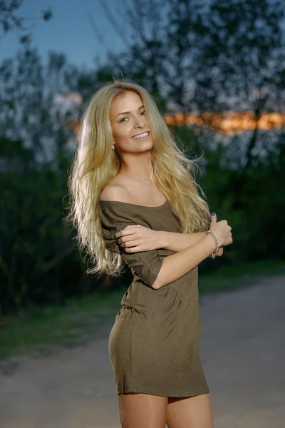 Outdoor portrait of pretty blonde woman in sunset time on the ro