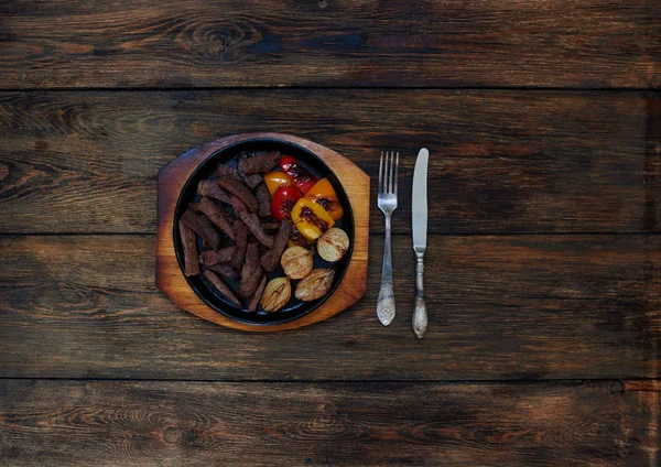 Cut into pieces of meat lying in a ceramic baking dish in the oven