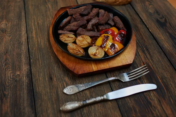 Cut into pieces of meat lying in a ceramic baking dish in the oven