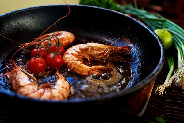 There are shrimps in a cast iron skillet