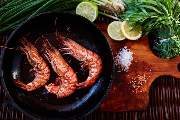 There are shrimps in a cast iron skillet