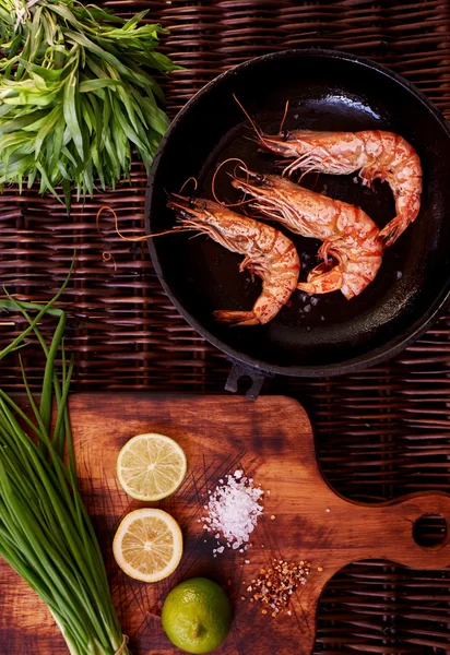 There are shrimps in a cast iron skillet