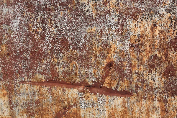 Rusty metal surface with old paint and scratches.