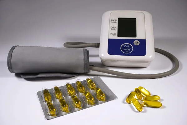 Fish oil capsules and tonometer for measuring blood pressure.