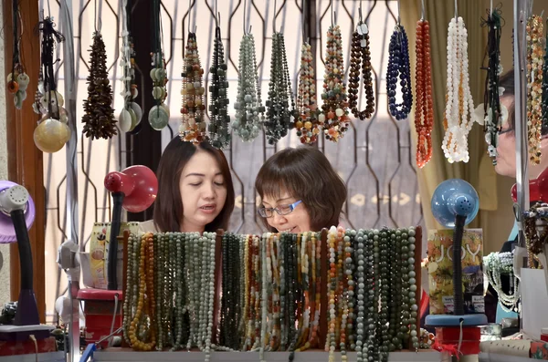 Yangon, Myanmar. February 28, 2014. Shoppers choosing the necklace before buying it at gems  retail center.