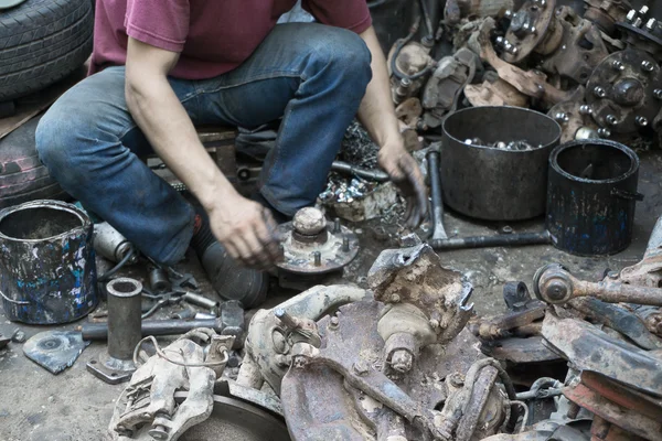 Man at work. Worker separating spare parts at workshop.