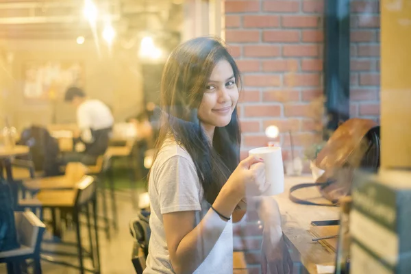 Attractive female Asian university student drinking coffee