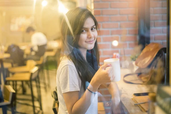 Attractive female Asian university student drinking coffee