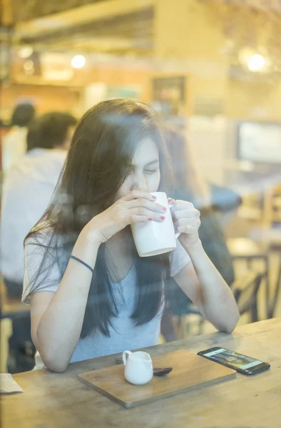 Attractive female Asian university student drinking coffee
