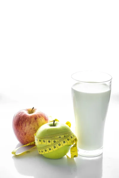 Glass of milk with apple isolated on white, selective focus