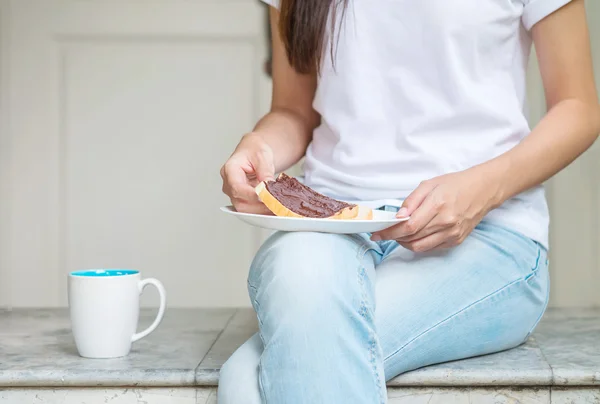 Asian woman sitting on marble chair in front of house for have breakfast in the morning