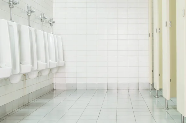 Closeup tiles wall in the toilet of man with toilet view by urinals and small room , interior at the old toilet background