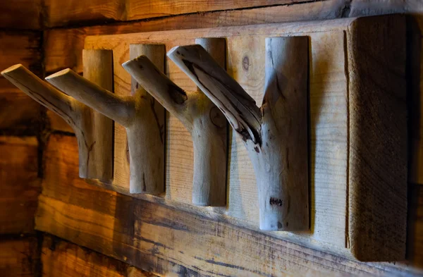 Wood hooks are attached to a wall of wood