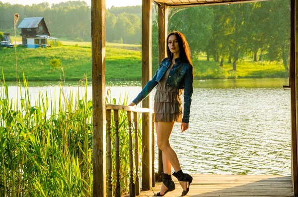 Girl standing on a wooden pier .