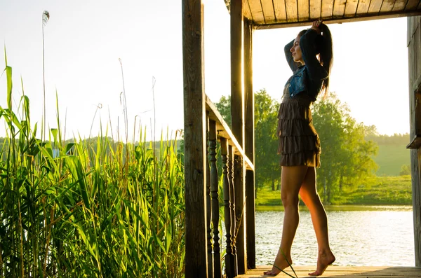 Girl standing on a wooden pier .