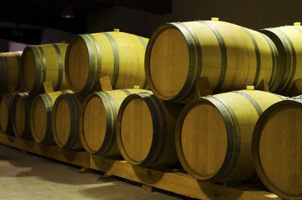 Wine barrels with red wine leak in a cellar. Selective focus