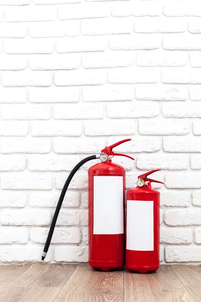 Fire extinguishers near white wall