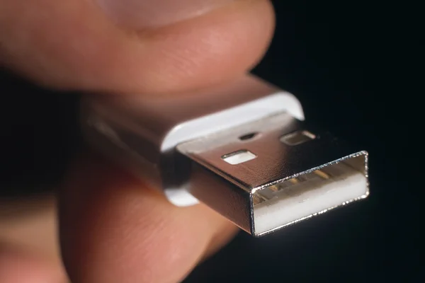 Hand holding white USB cable. Man\'s hand holds a USB Connector. Closeup man hand holding USB cable.Selective focus and shallow Depth of field.