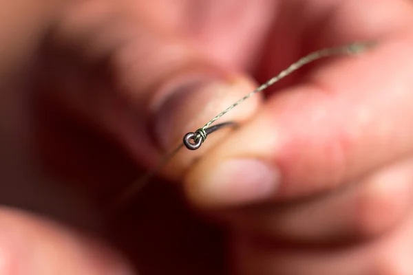 Man hand tying a fishing hook. Tie the KD rig.  Selective focus. Tie Hook Close Up. Tie Fishing Hook  Tying a fishing hook Process. Tie the KD rig and catch more carp.