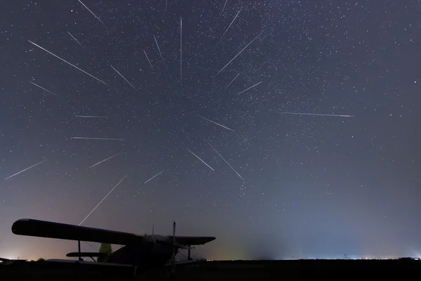 Meteor Shower. Falling stars. Meteor Shower starry night. Perseid meteor shower. Real night sky, Starry night. Light pollution. Silhouette of airplane. Composite Photo of Perseid meteor activity