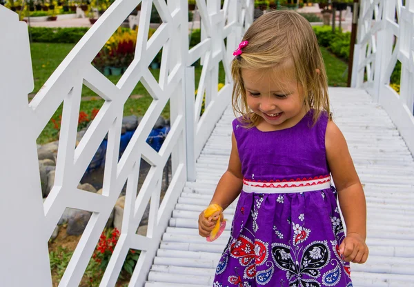 Little girl laughing.  she goes over the white bridge