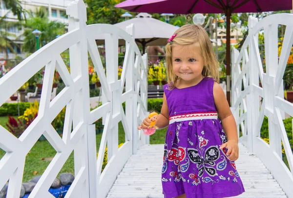 Little girl laughing.  she goes over the white bridge