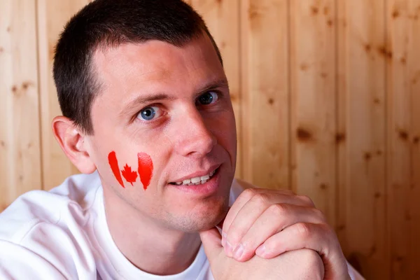 Canadian flag on the face of young man