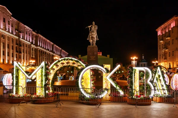 Moscow night cityscape. Monument to prince Yury Dolgorukiy, the founder of Moscow, on Tverskaya square. Floral decorations on illuminated letters 